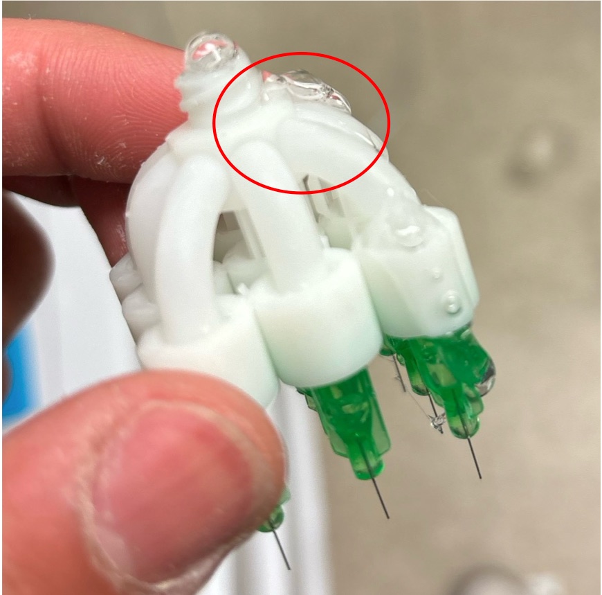 The original printed manifold with fluid leaking near the top